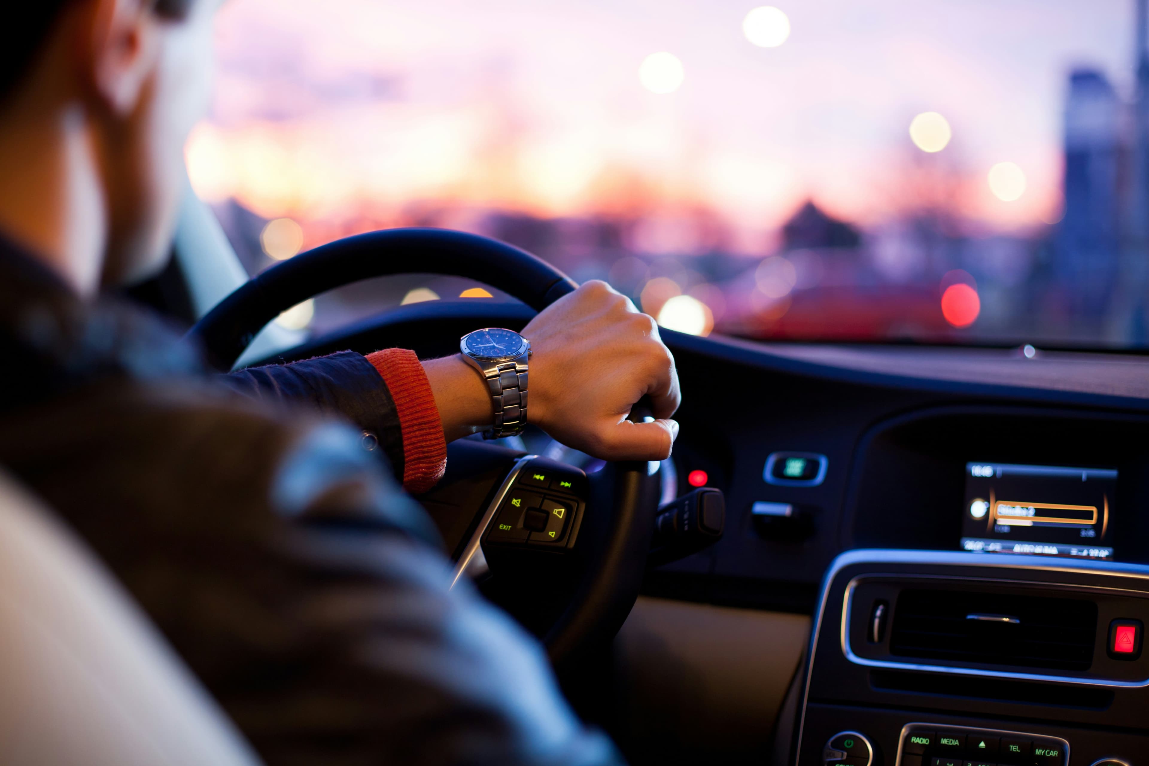 A Stratus chauffeur at the wheel at dusk